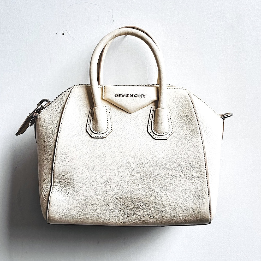 Off white leather . Tags attached. Strap included. Duster. Lightly worn .